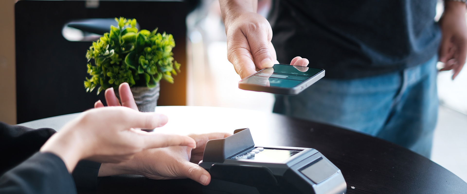 Bespoke Fintech Development | photo of a person tapping their phone onto a card reader to pay for an item